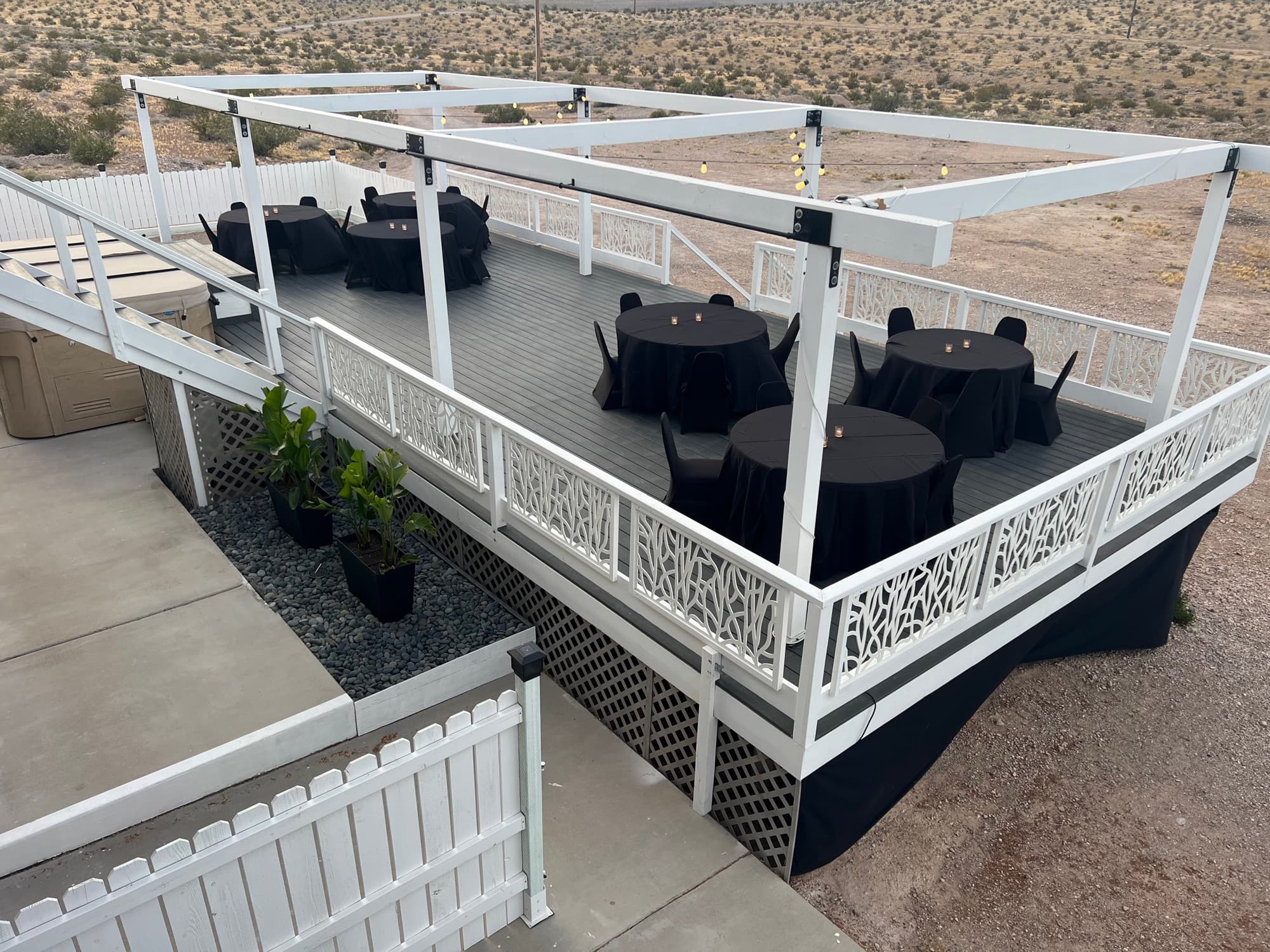 Daytime exterior view of the full upper deck structure with round tables set up for an event