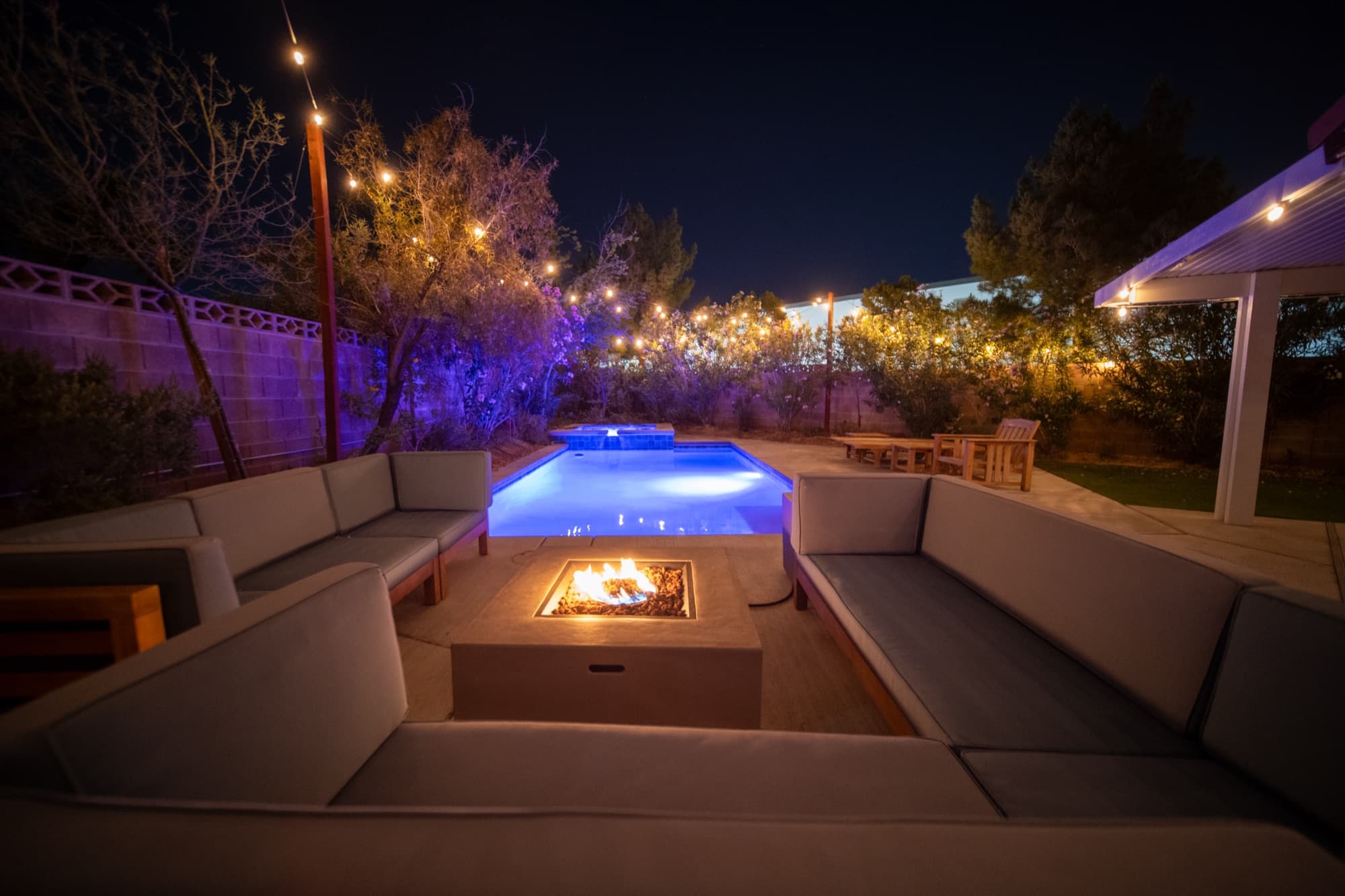 Backyard pool and fire pit lounge lit up at night with string lights, Summerlin Las Vegas